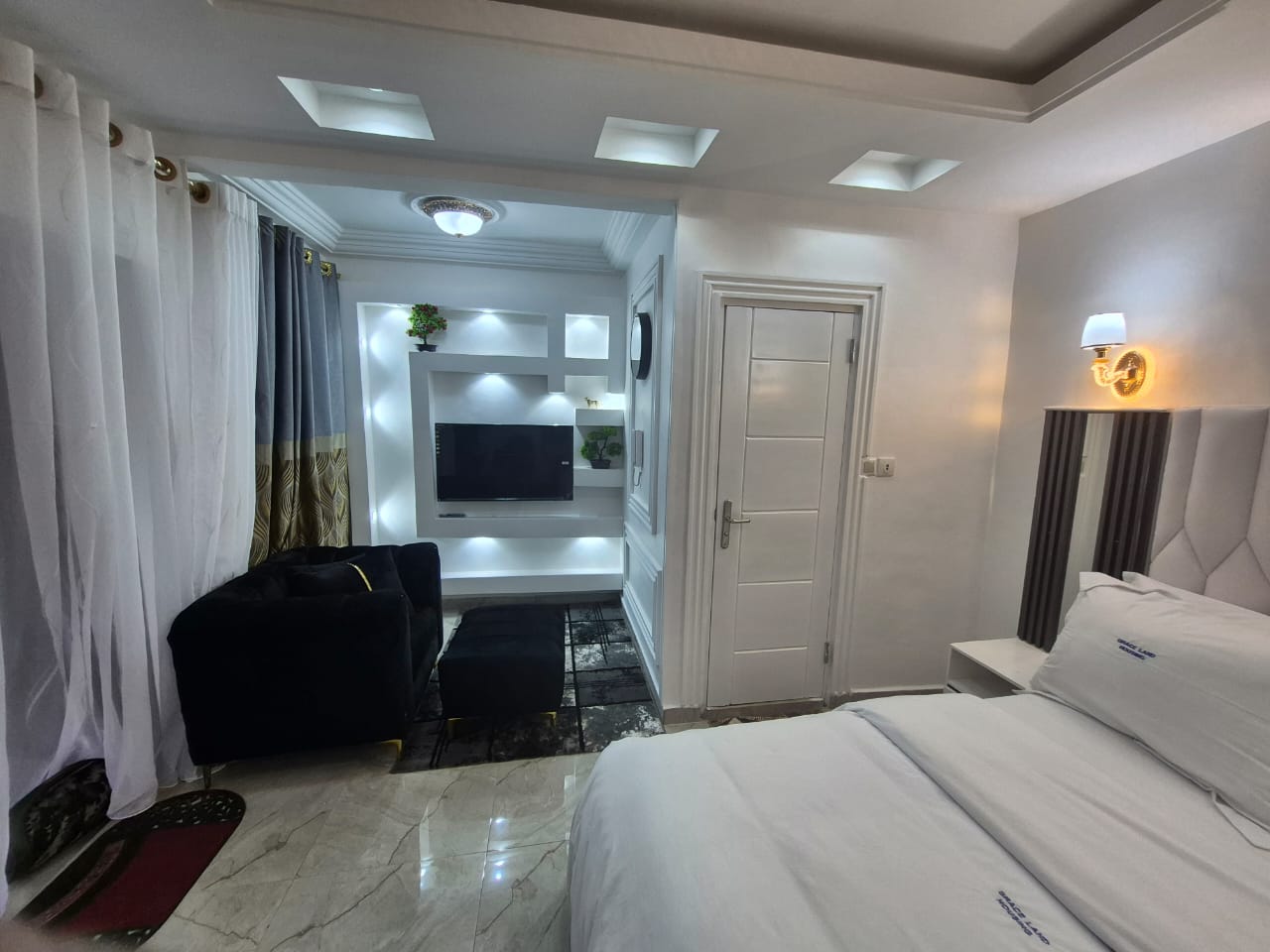Backlit TV wall, velvet seating and marble flooring