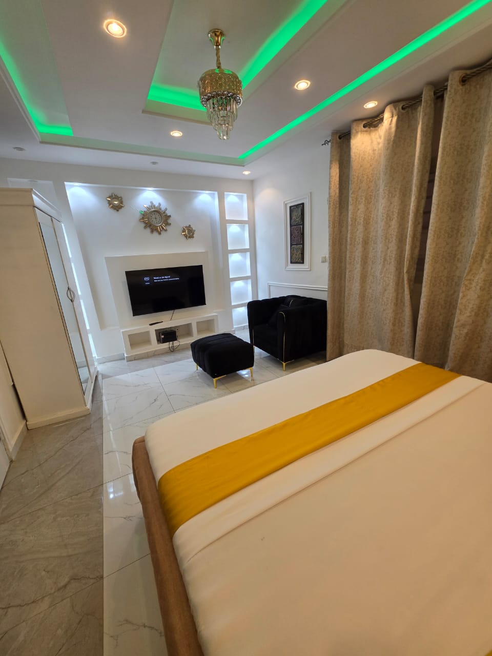 VIP bedroom with chandelier, velvet armchair and smart TV