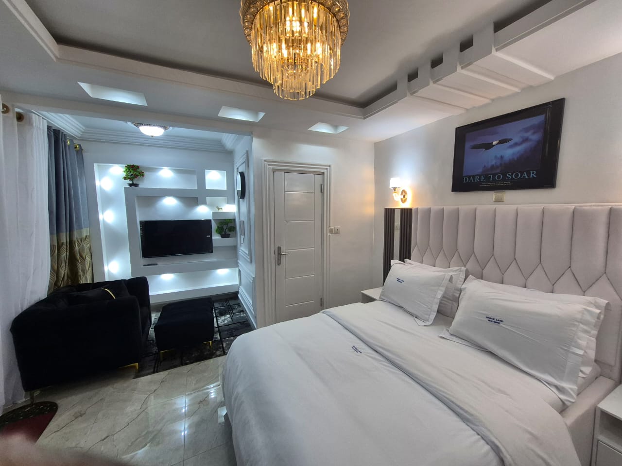 Upholstered king bed, velvet armchair and marble floors