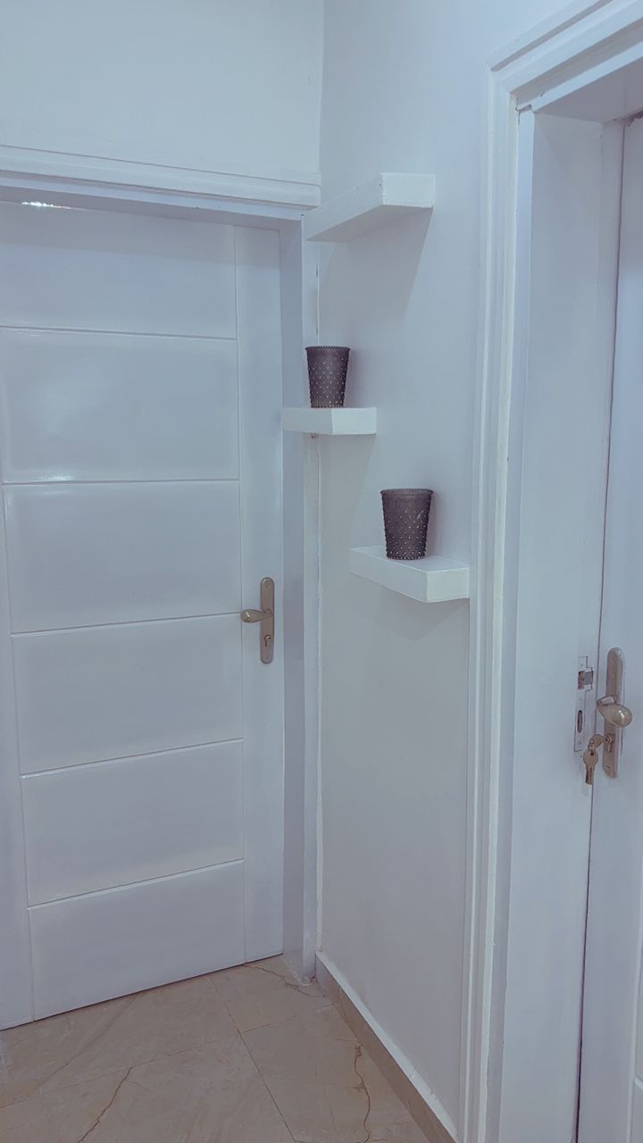 Private entry hall with bathroom door and display shelves