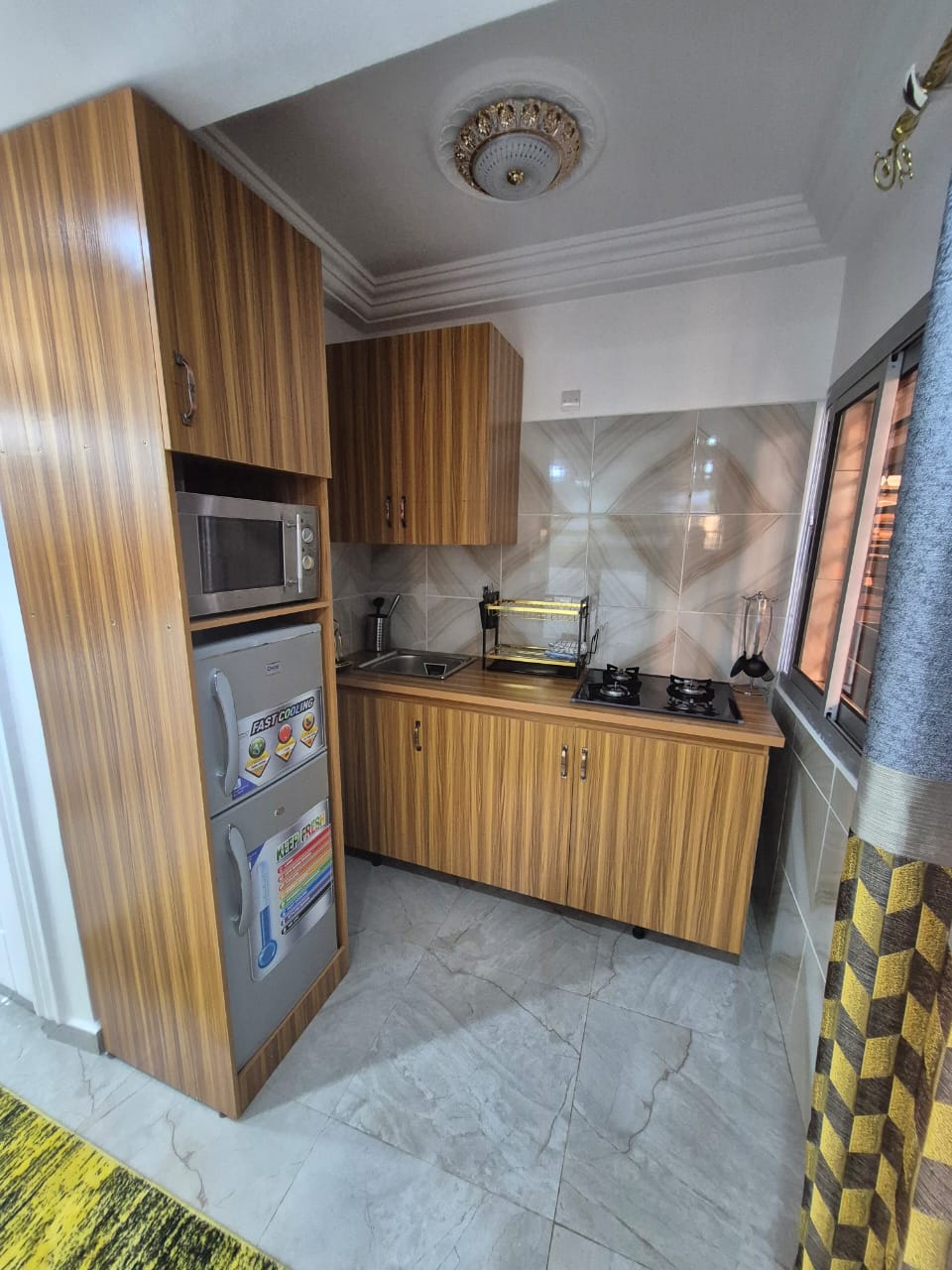 Kitchenette with window, storage column and marble floors